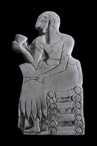 Fig. 5 : Homme assis tenant un gobelet dans la main droite et un rameau de dattes dans la main gauche (temple de Ninni-Zaza, Mari, Syrie ; coquille non nacrée ; ht. 6,4 cm, l. 3,8 cm) © Mission archéologique de Mari
